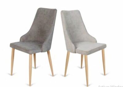 Silla tapizada en tela con ribete en todo el perímetro de la silla. Patas de metal con apariencia de madera. También disponible en gris oscuro.